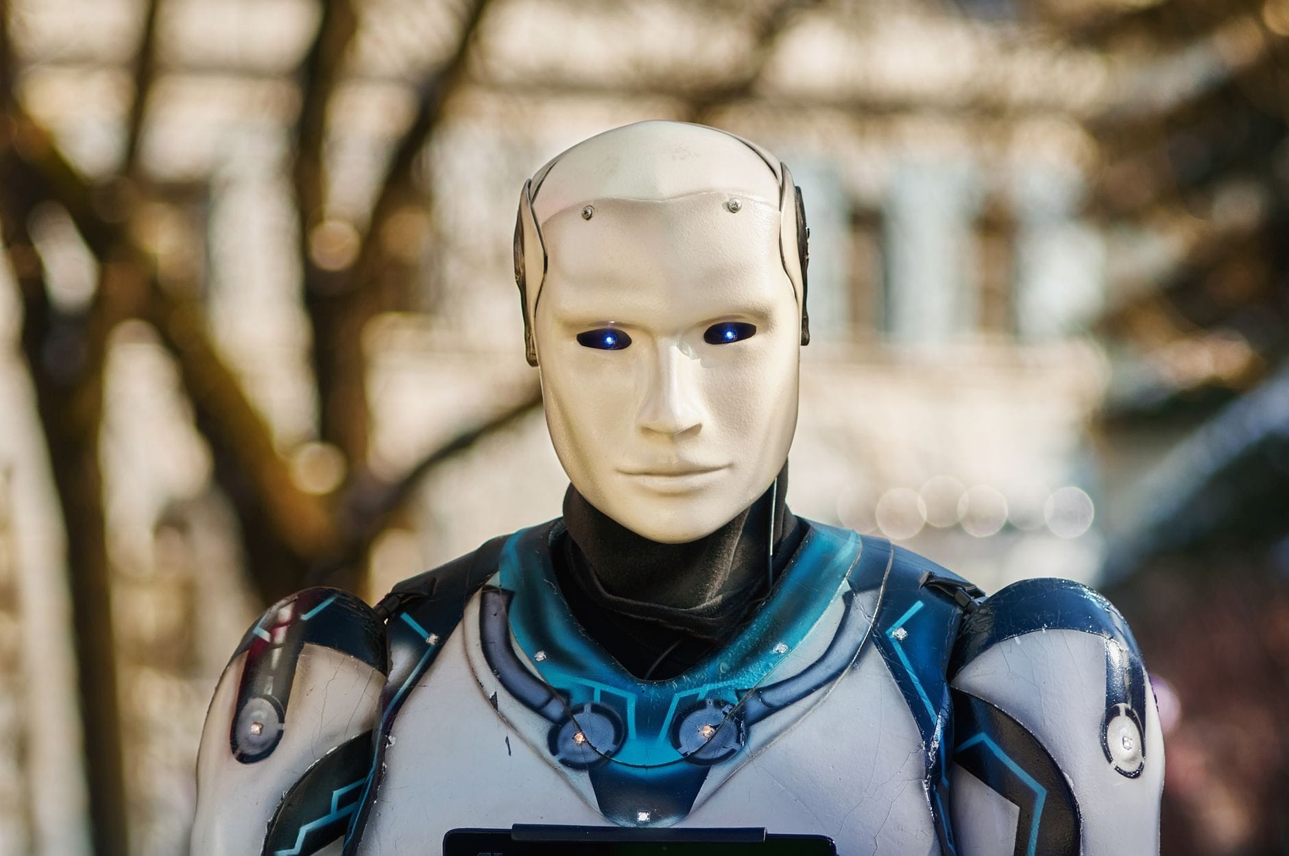 Przewodnik po sztucznej inteligencji dla początkujących: jak zacząć przygodę z AI i nowymi technologiami Humanoidalny robot o futurystycznym wyglądzie na tle miasta